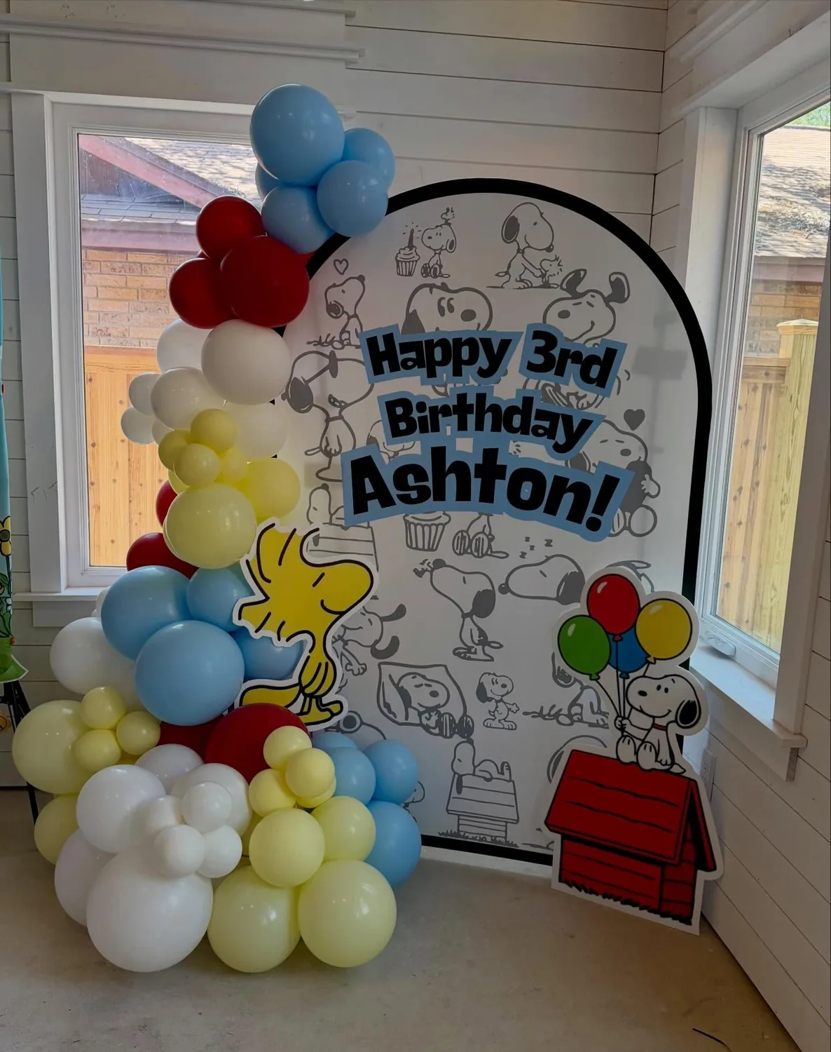 Colorful Snoopy-themed third birthday balloon display
