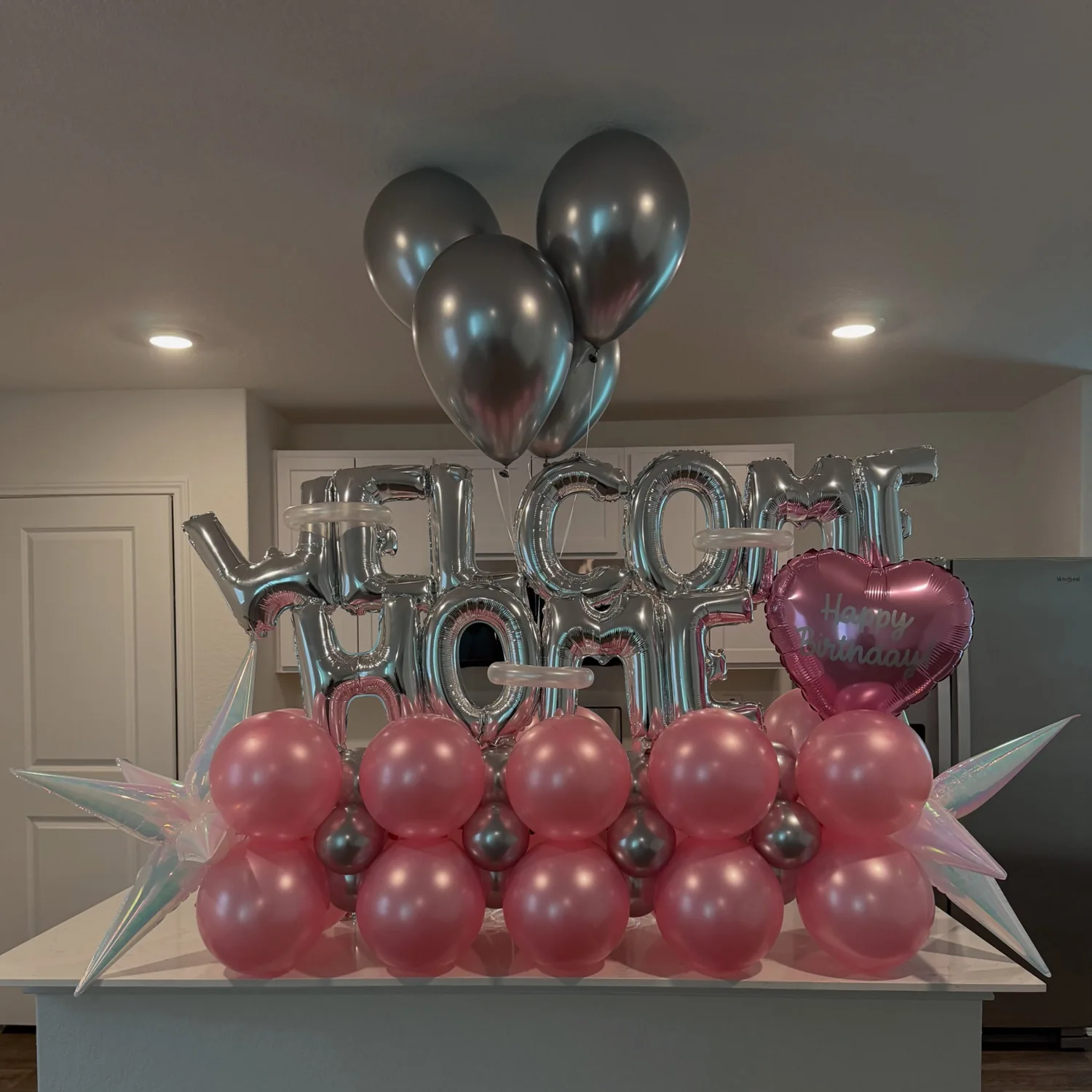 Silver Welcome Home balloons above glossy pink balloon arrangement